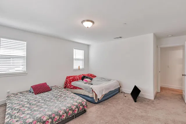 a bedroom with two bed and a window