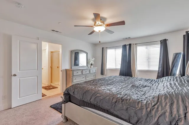 a spacious bedroom with a large bed and a chandelier