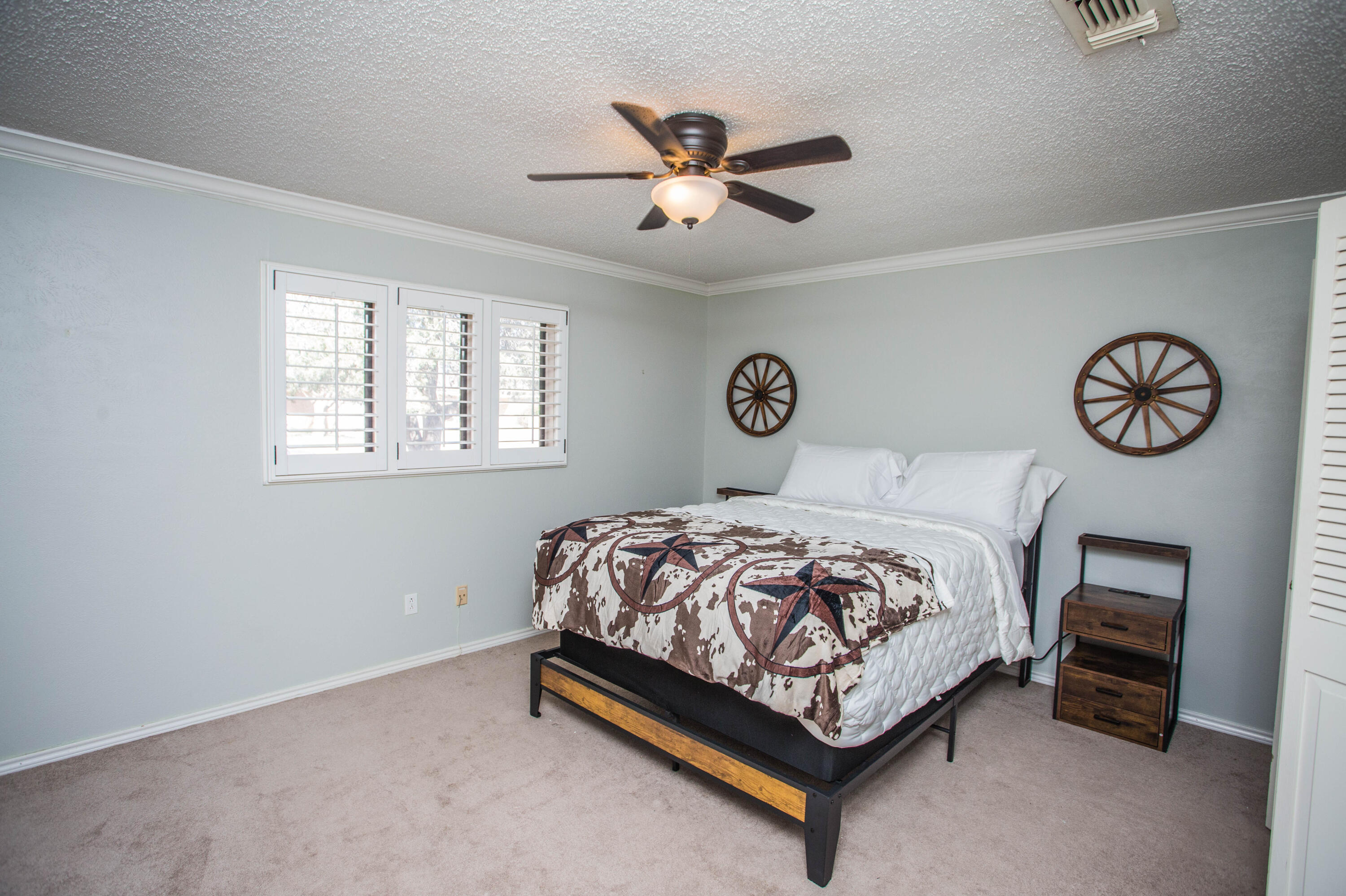 5407 79th Street Lubbock, TX 79424 - Photo 12 of 19 a bedroom with a bed and a chandelier