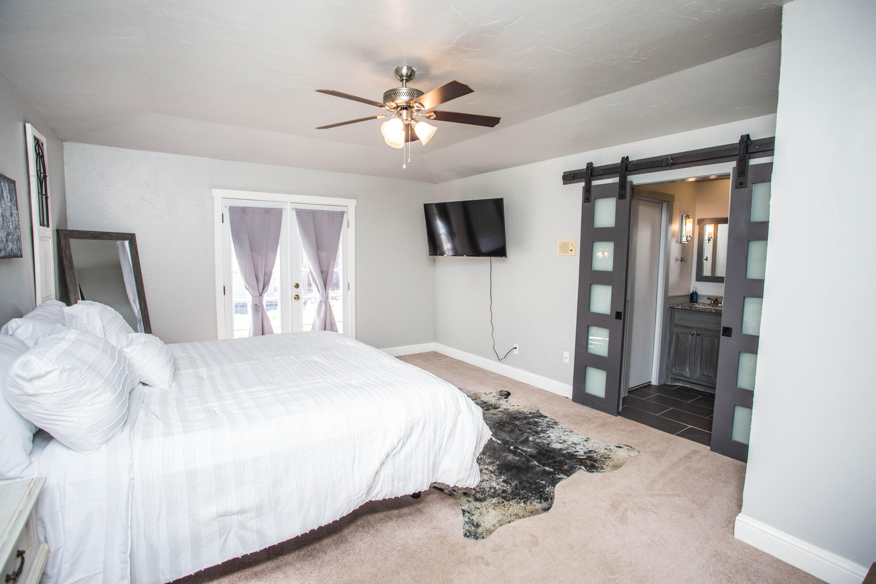 5407 79th Street Lubbock, TX 79424 - Photo 15 of 19 a bedroom with a large bed and a flat tv screen on dresser