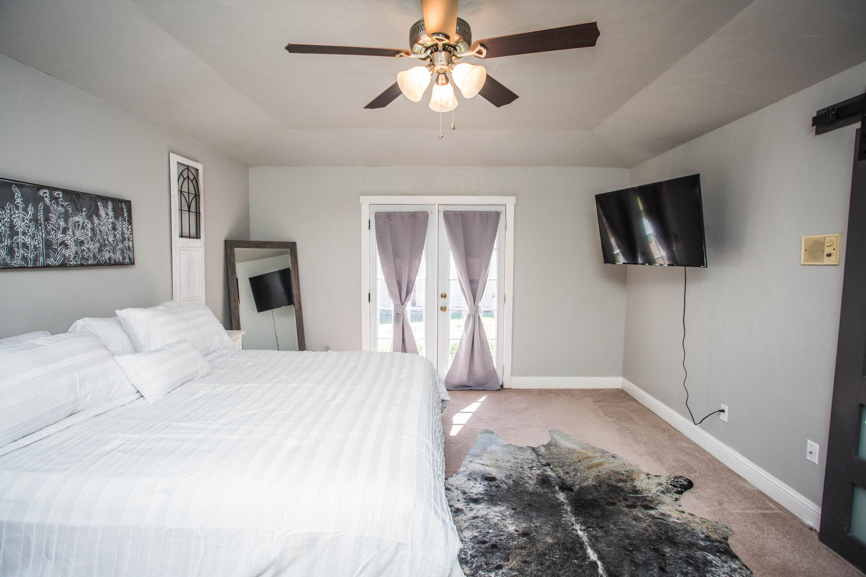 5407 79th Street Lubbock, TX 79424 - Photo 17 of 19 a bedroom with a large bed and a flat tv screen on a dresser