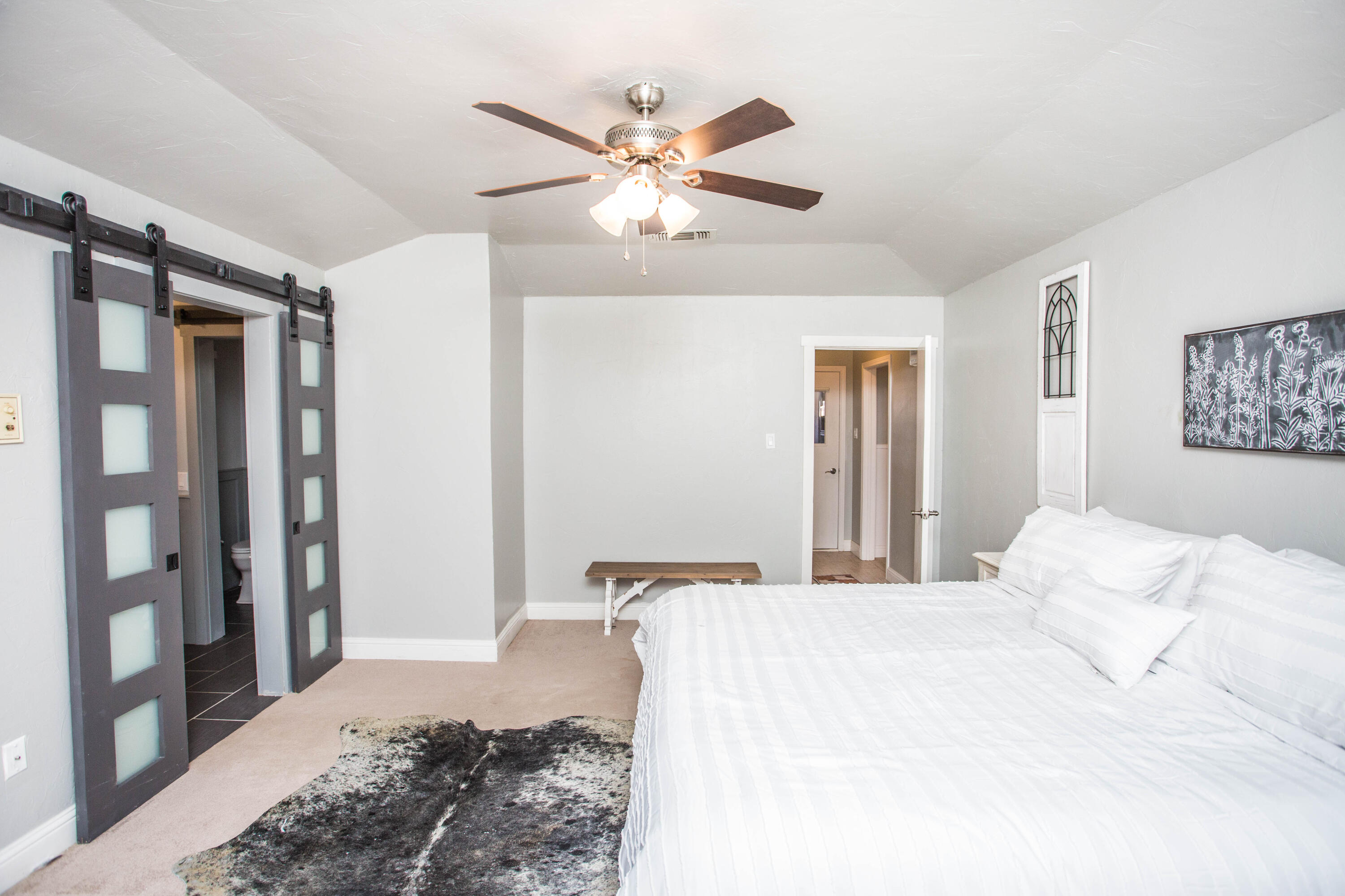 5407 79th Street Lubbock, TX 79424 - Photo 18 of 19 a bedroom with a large bed and a chandelier