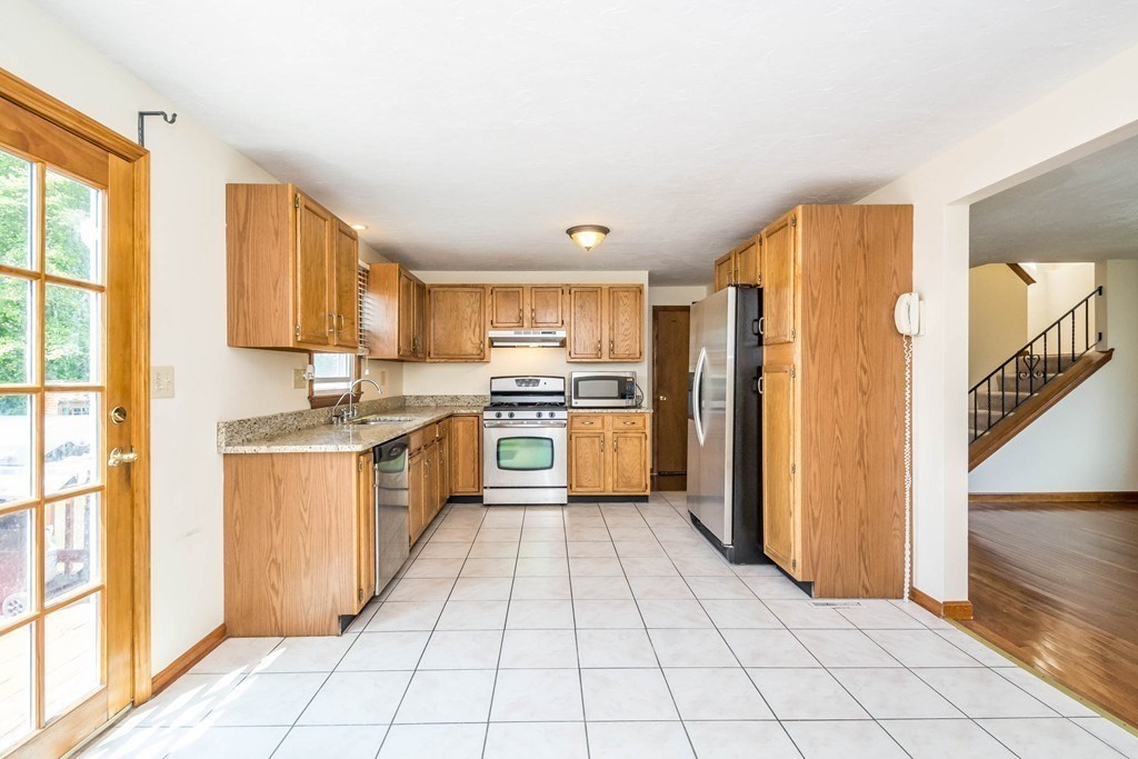 2 Fred Dolan Circle, Unit 2 Randolph, MA 02368 - Photo 4 of 25 a kitchen with a sink a counter top space stainless steel appliances cabinets and a window