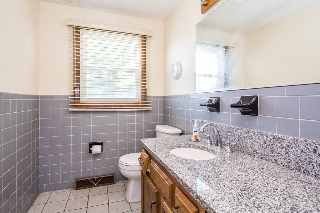 2 Fred Dolan Circle, Unit 2 Randolph, MA 02368 - Photo 6 of 25 a bathroom with a granite countertop sink a toilet and a mirror