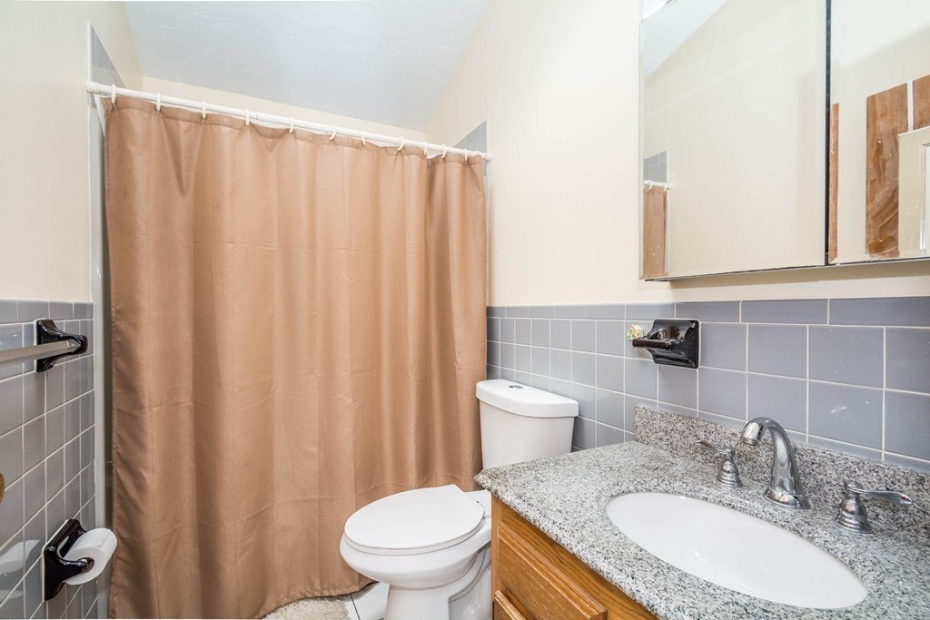 2 Fred Dolan Circle, Unit 2 Randolph, MA 02368 - Photo 7 of 25 a bathroom with a granite countertop sink and a toilet