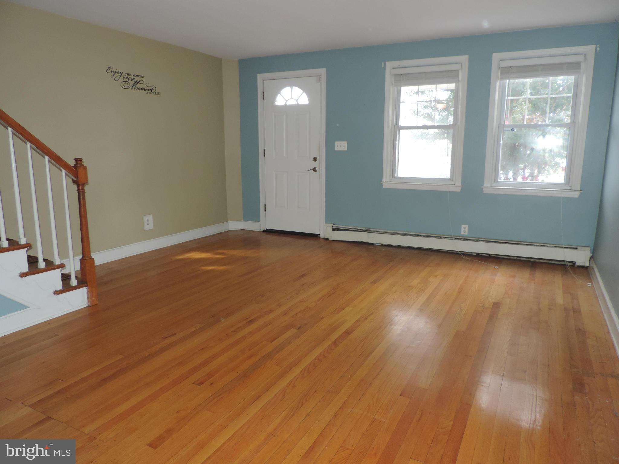 1124 Elm Road Baltimore, MD 21227 - Photo 4 of 13 a view of an empty room with wooden floor and a window