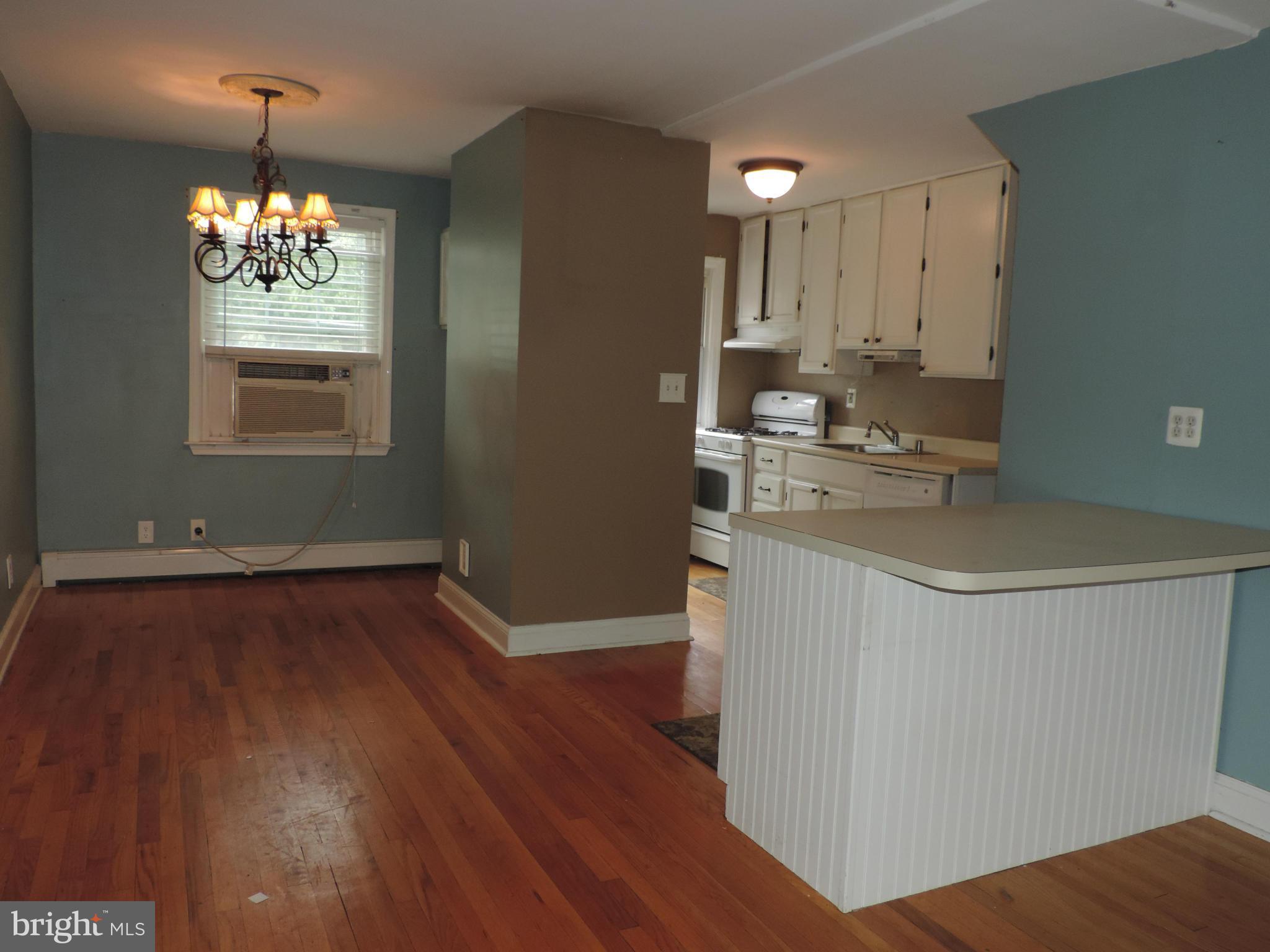 1124 Elm Road Baltimore, MD 21227 - Photo 5 of 13 a kitchen with stainless steel appliances granite countertop a dishwasher a stove a sink dishwasher and a dining table with wooden floor