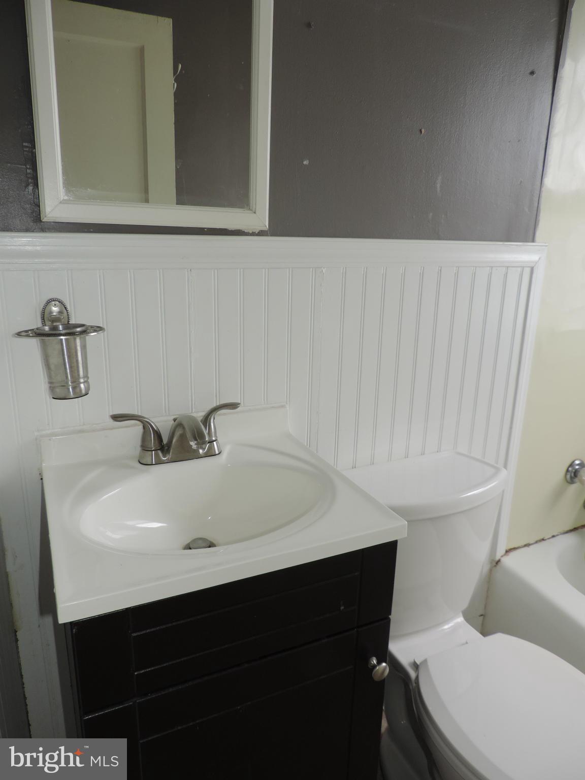 1124 Elm Road Baltimore, MD 21227 - Photo 9 of 13 a bathroom with a sink a toilet and mirror