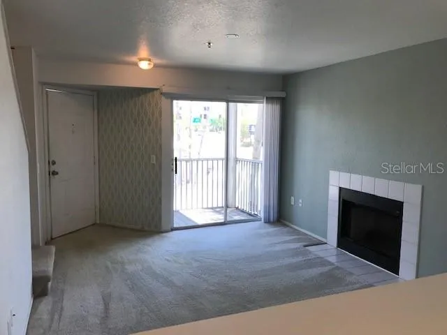 an empty room with windows and fireplace