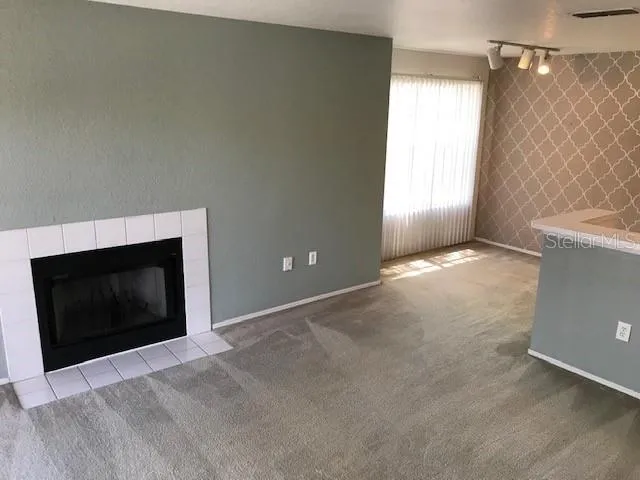 a view of an empty room with a fireplace and a window