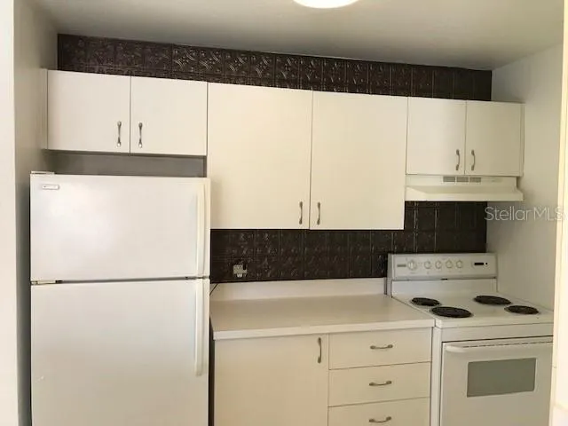 a kitchen with a refrigerator and a stove