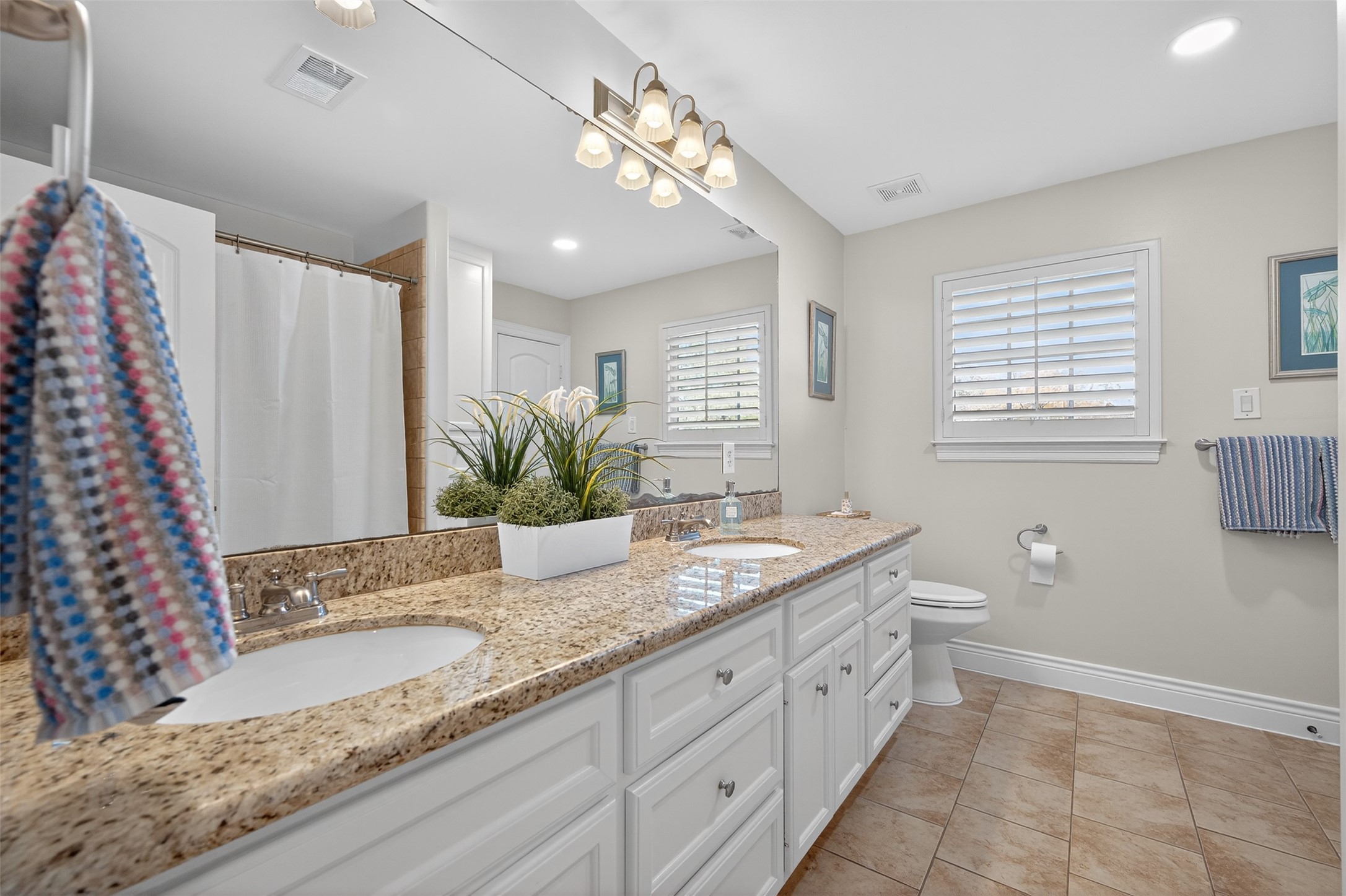 13315 Tosca Lane Houston, TX 77079 - Photo 27 of 42 a spacious bathroom with a granite countertop sink a toilet a mirror and a shower