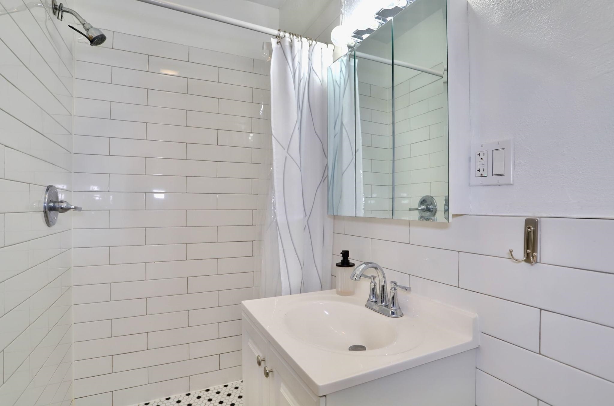 402 Monroe Street, Unit 2 Hoboken, NJ 07030 - Photo 11 of 22 a bathroom with a sink shower and a mirror