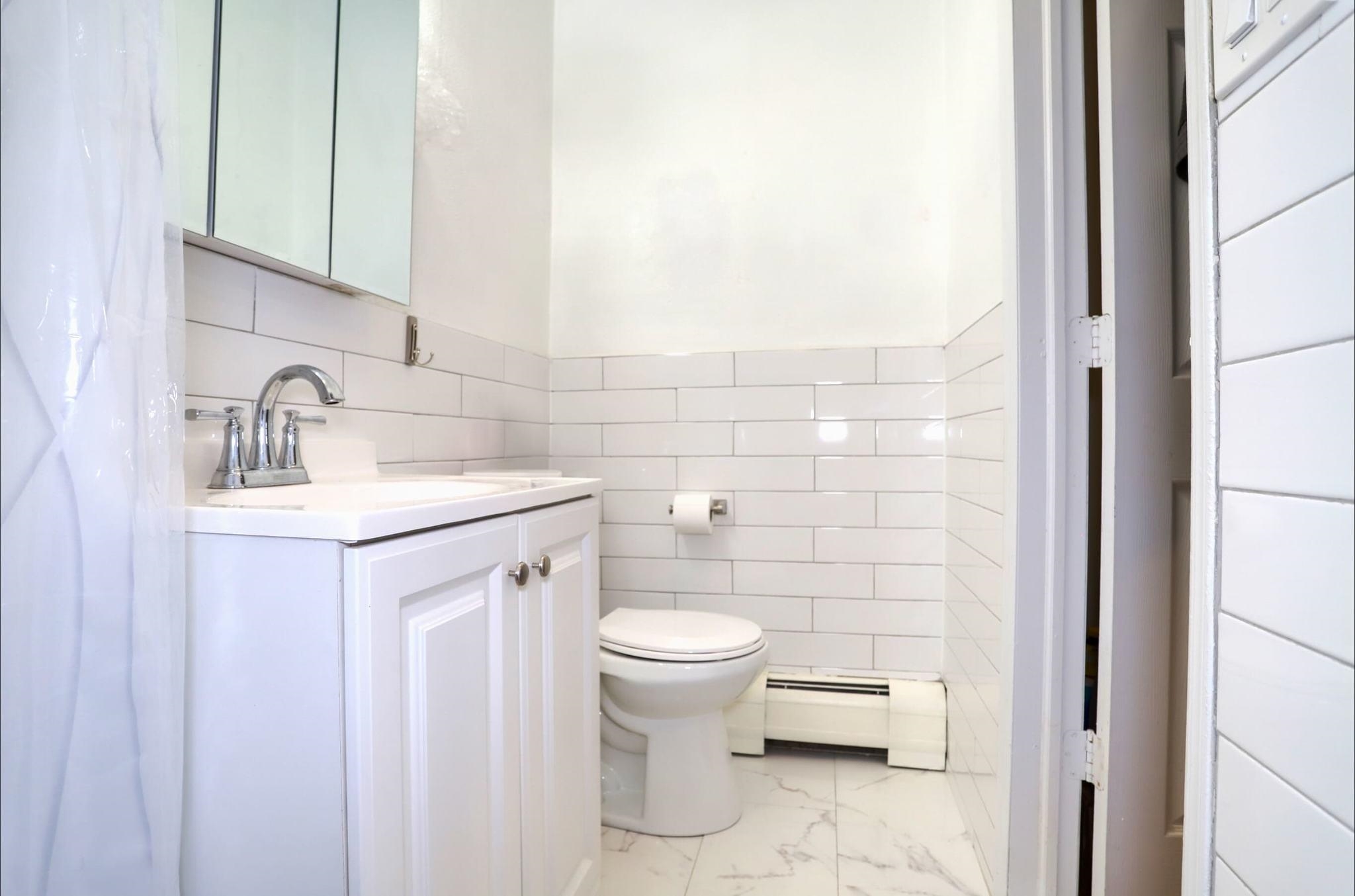 402 Monroe Street, Unit 2 Hoboken, NJ 07030 - Photo 12 of 22 a bathroom with a sink toilet and a mirror
