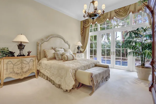 a spacious bedroom with a bed and a chandelier