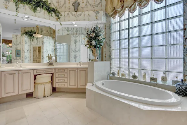 a bathroom with a bathtub a sink a mirror and a shower