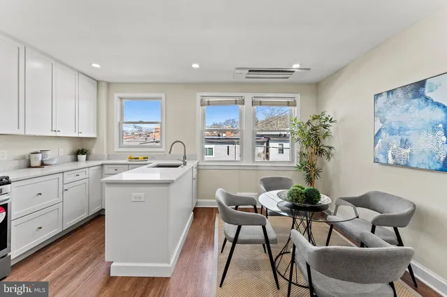 a kitchen with a table chairs and white cabinets
