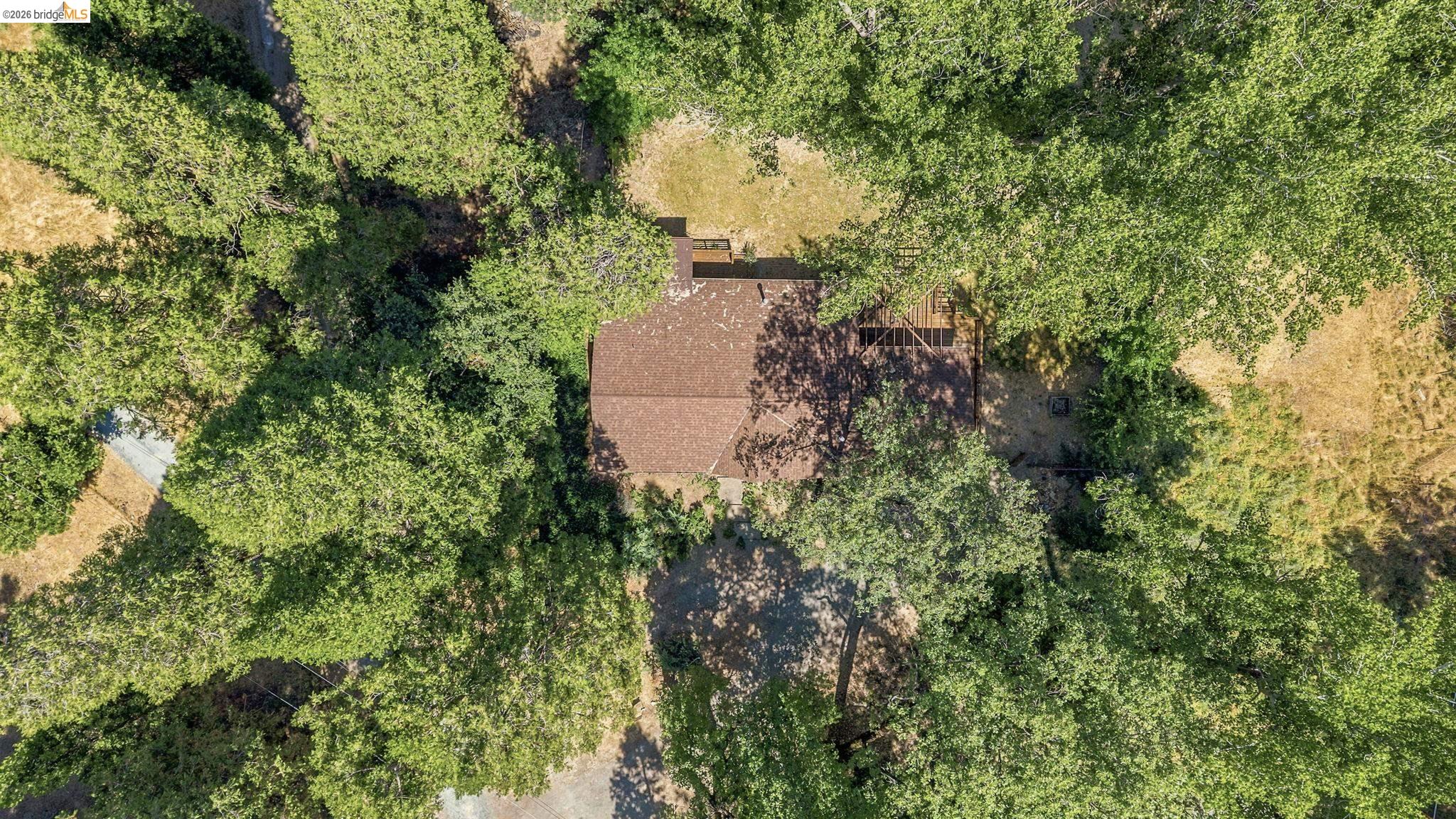 22401 South Fork Road Sonora, CA 95370 - Photo 27 of 34 Residential structure featuring a shingle roof and surrounding mature trees