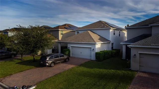 a front view of a house with a garden and parking space