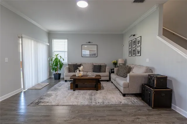 a living room with stainless steel appliances kitchen island hardwood floor and a kitchen counter top