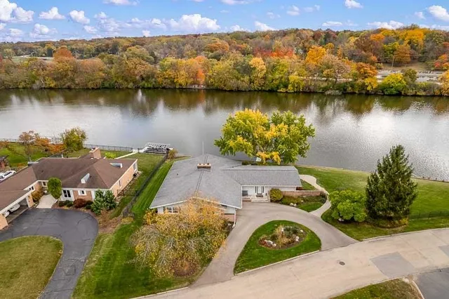 a kitchen with stainless steel appliances kitchen island granite countertop a stove a refrigerator and a dining table with wooden floors