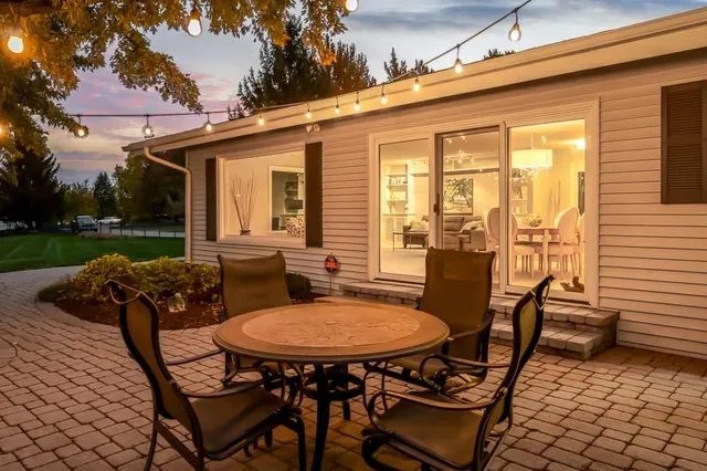 a backyard of a house with table and chairs