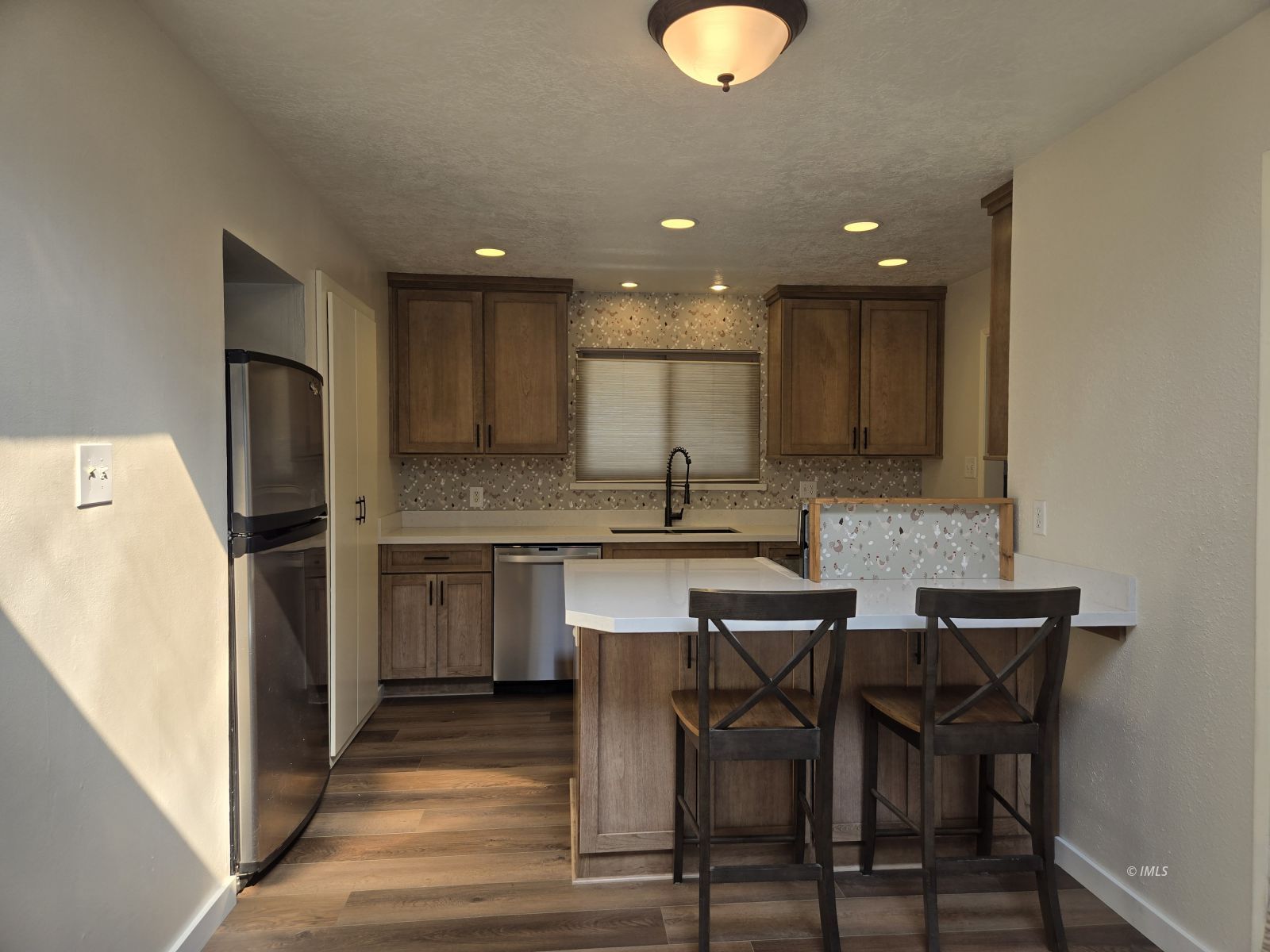 3028 Laurel Road Bishop, CA 93514 - Photo 6 of 21 a kitchen with a table chairs refrigerator and microwave