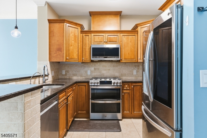 21 Freeman Street, Unit A2 Newark, NJ 07105 - Photo 3 of 24 a kitchen with stainless steel appliances granite countertop a stove and a refrigerator