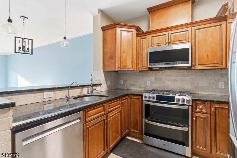 21 Freeman Street, Unit A2 Newark, NJ 07105 - Photo 8 of 24 a kitchen with stainless steel appliances granite countertop a sink stove and microwave