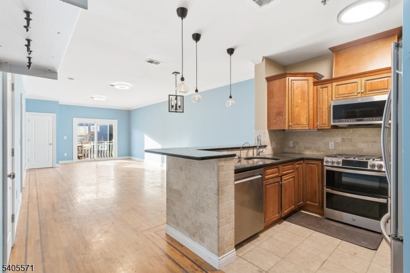 21 Freeman Street, Unit A2 Newark, NJ 07105 - Photo 9 of 24 a kitchen with stainless steel appliances granite countertop a stove and a refrigerator