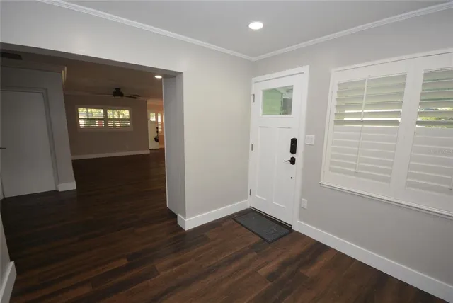 a view of a hallway with wooden floor and entryway