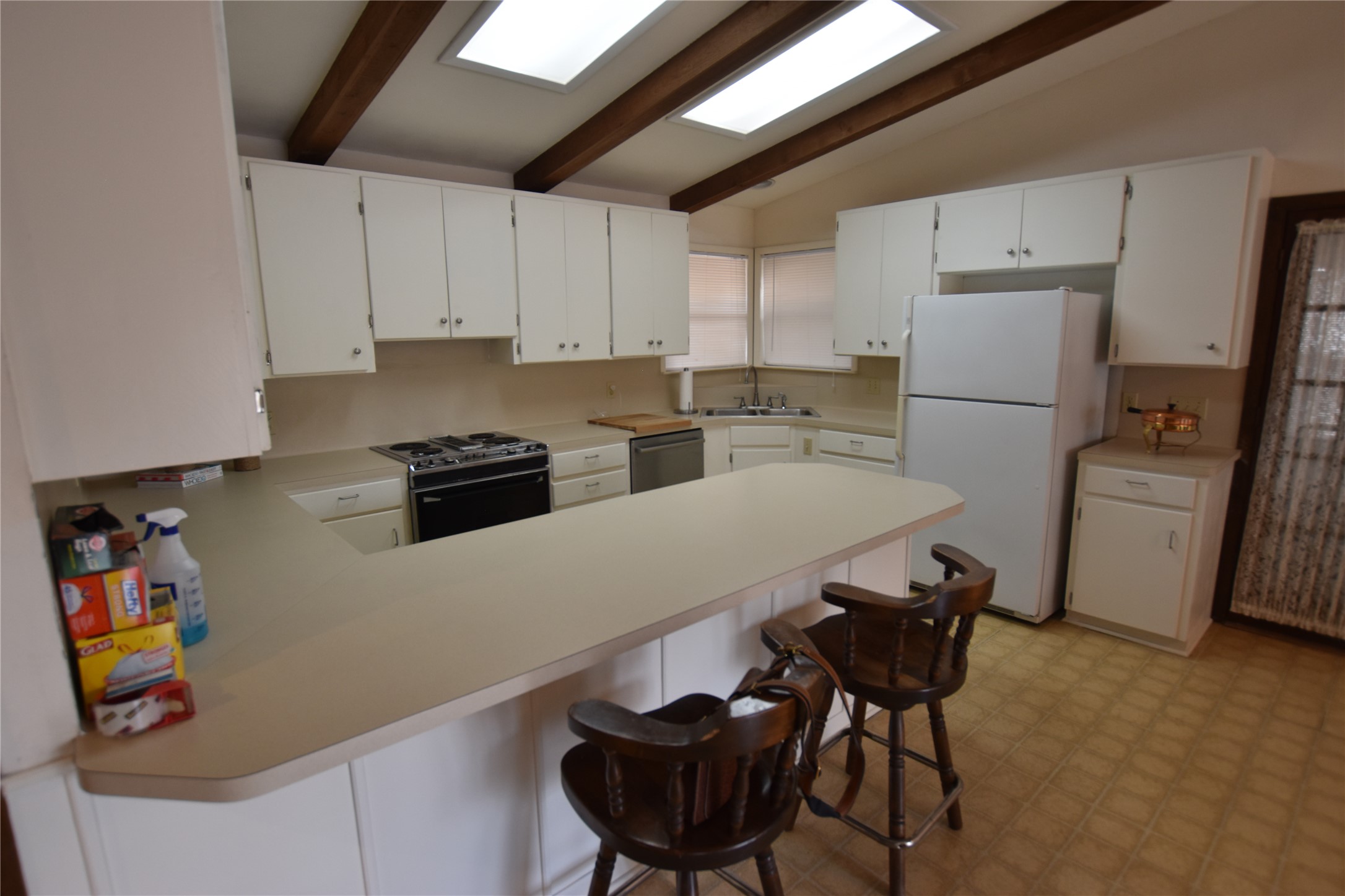 687 Fm 812 Road Red Rock, TX 78662 - Photo 8 of 40 Kitchen featuring light flooring, a kitchen bar, a peninsula, light countertops, and freestanding refrigerator