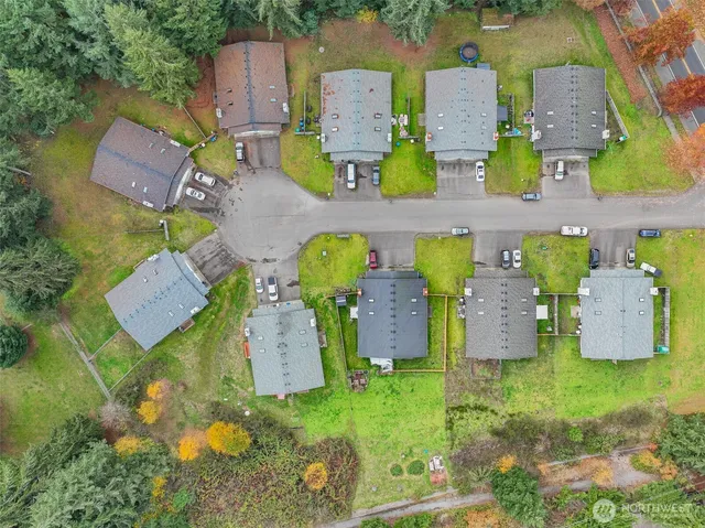 an aerial view of residential houses with outdoor space and parking