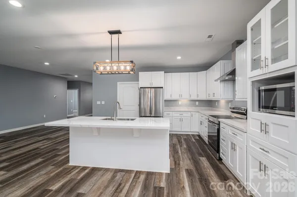 a kitchen with white cabinets and refrigerator