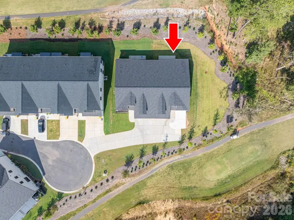 an aerial view of residential houses with outdoor space and lake view