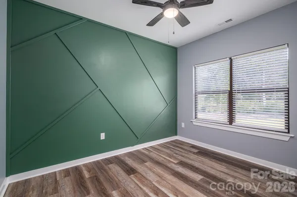 a view of empty room with window and fan