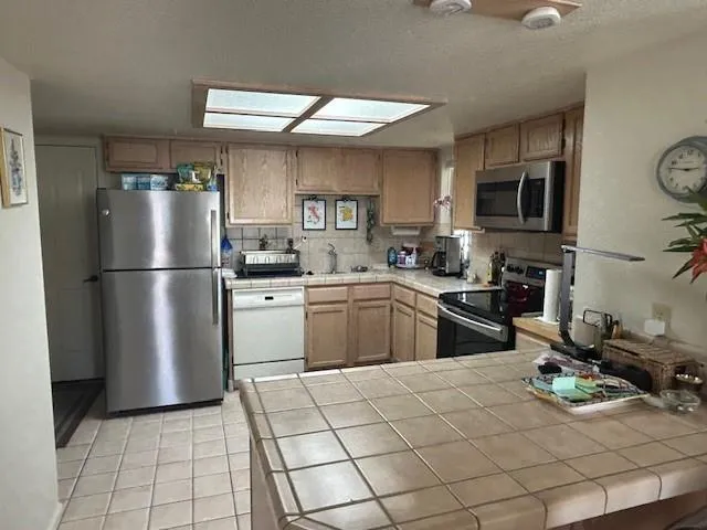 a kitchen with a sink a refrigerator and cabinets