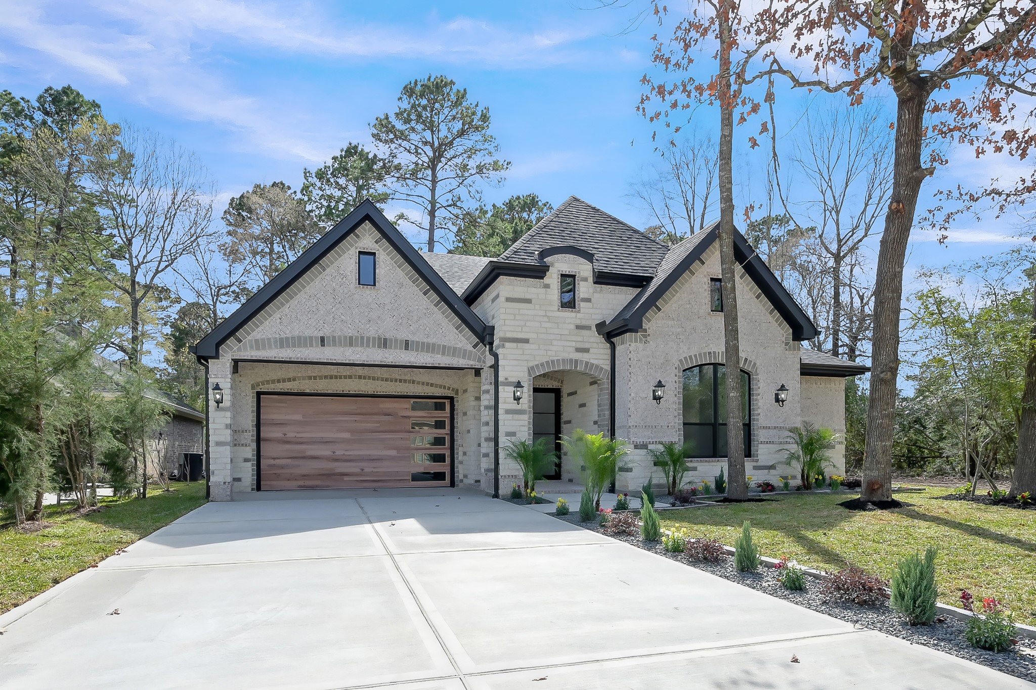 135 Wick Willow Road Montgomery, TX 77356 - Photo 2 of 50 a front view of a house with a yard and garage