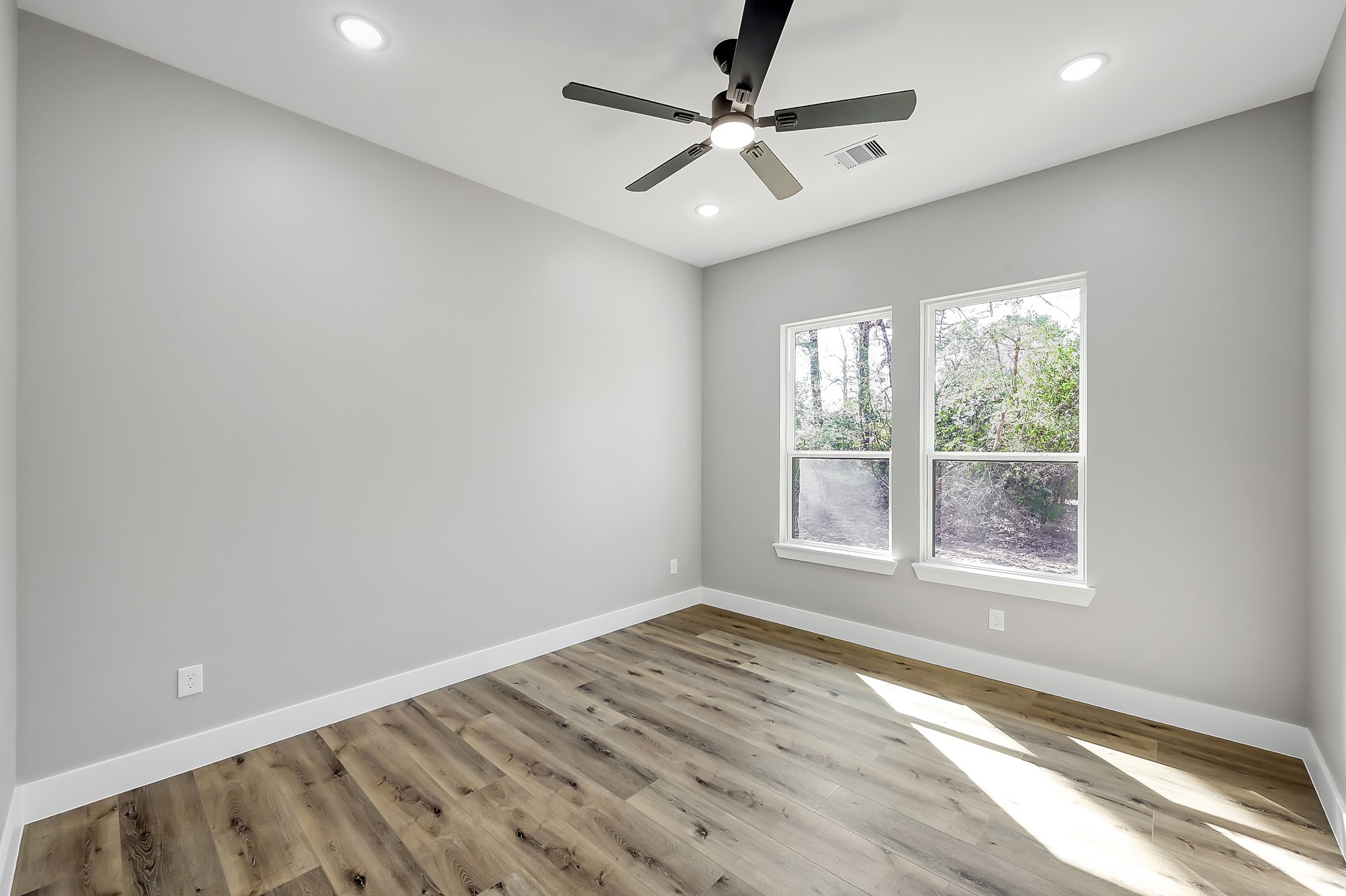 135 Wick Willow Road Montgomery, TX 77356 - Photo 41 of 50 an empty room with wooden floor fan and windows