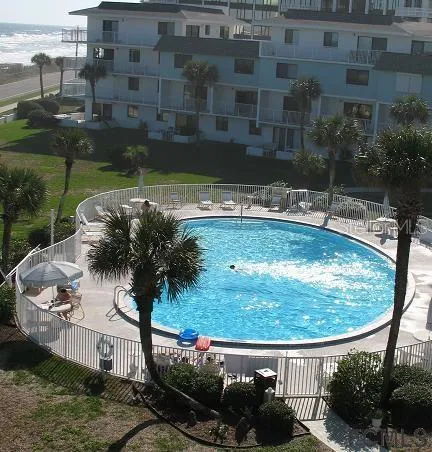 a view of a swimming pool with a patio and a yard
