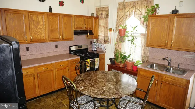 a kitchen with stainless steel appliances a sink a stove and a wooden cabinets