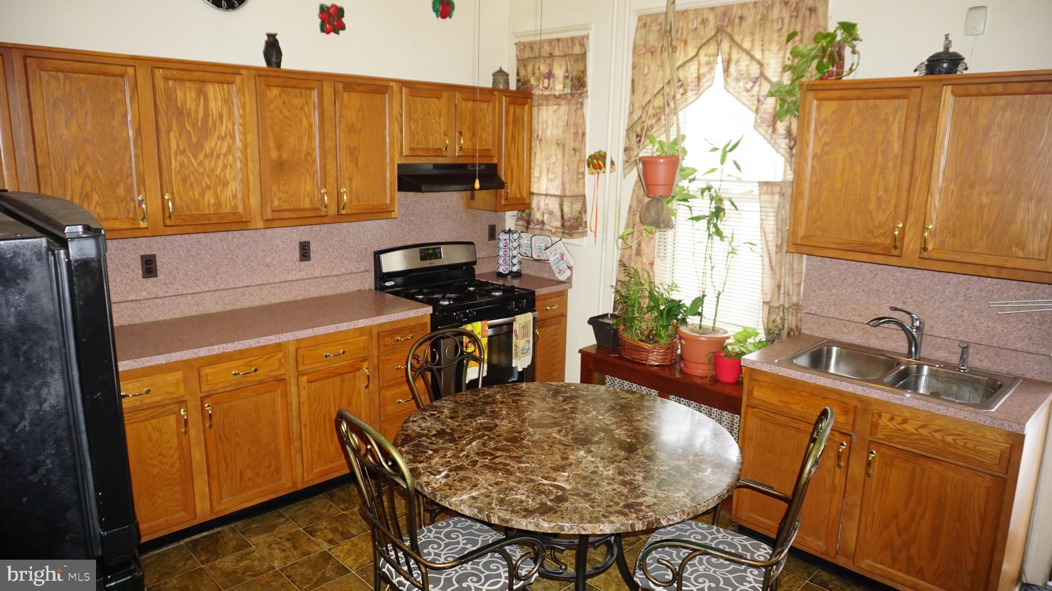 3005 Belair Road Baltimore, MD 21213 - Photo 2 of 33 a kitchen with stainless steel appliances a sink a stove and a wooden cabinets