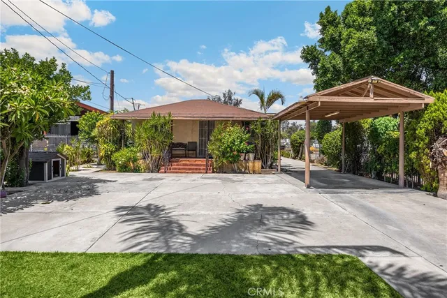 a view of a house with backyard and sitting area