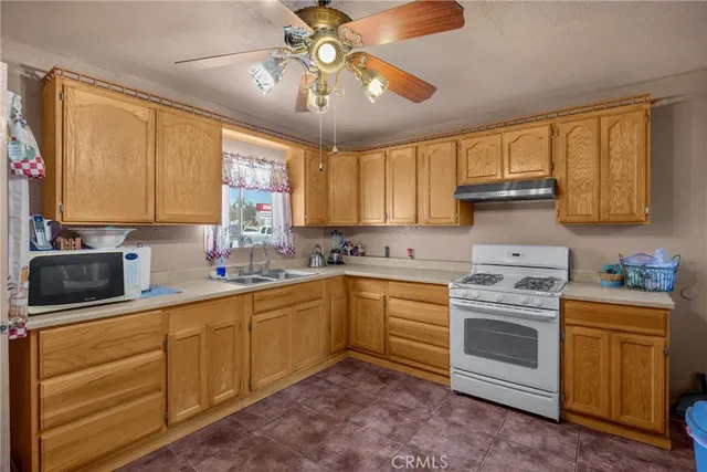 a kitchen with granite countertop a refrigerator oven a sink and dishwasher