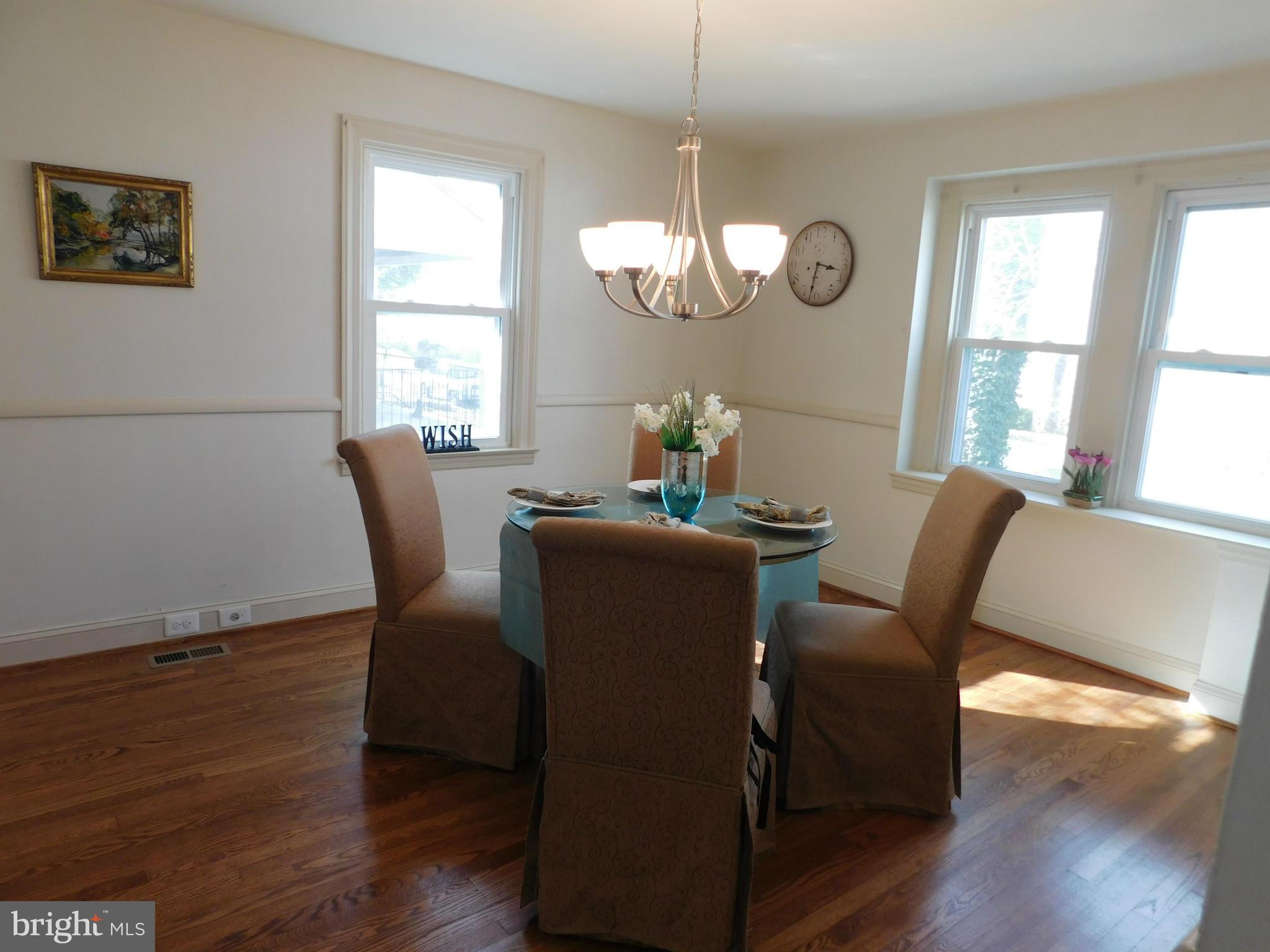 15 Summerfield Road Baltimore, MD 21207 - Photo 4 of 16 a dining room with wooden floor a glass table and chairs