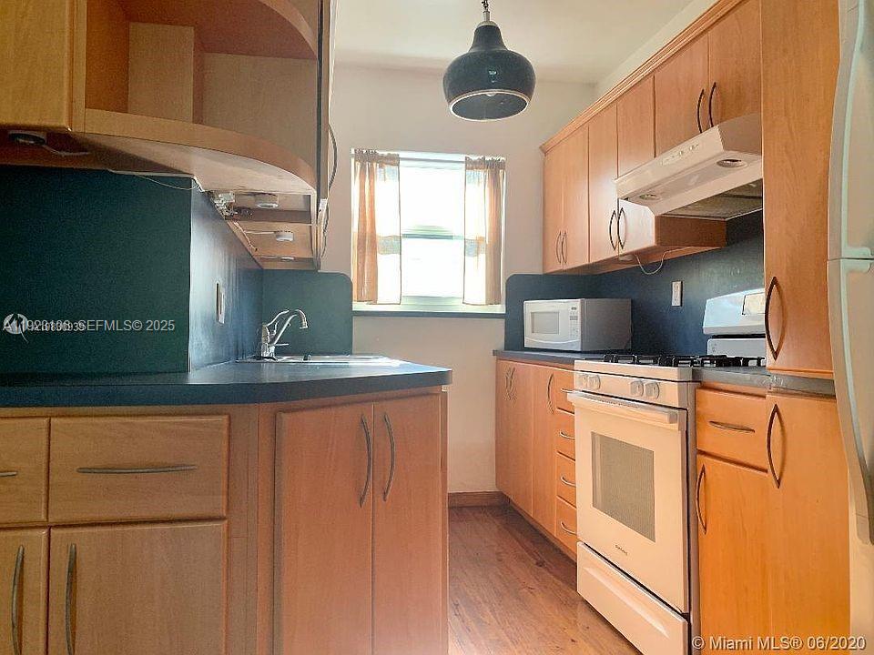a kitchen with stainless steel appliances granite countertop a sink a stove and a refrigerator