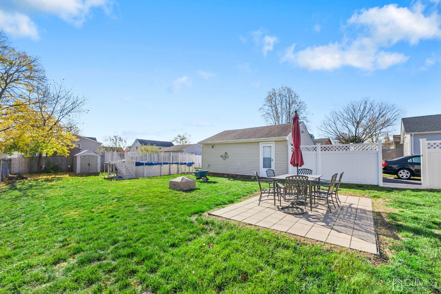 34 Walnut Street Edison, NJ 08817 - Photo 19 of 20 a view of a patio with table and chairs potted plants and a palm tree