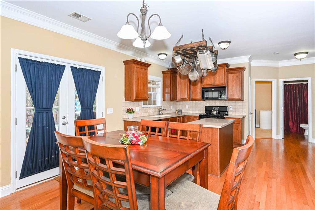 1024 Landon Drive Villa Rica, GA 30180 - Photo 18 of 50 a dining room with stainless steel appliances kitchen island granite countertop a table chairs and a chandelier