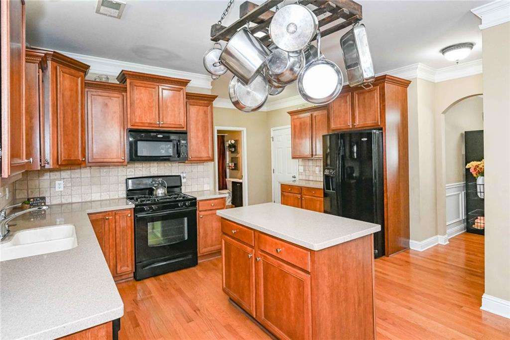 1024 Landon Drive Villa Rica, GA 30180 - Photo 22 of 50 a kitchen with stainless steel appliances granite countertop a stove top oven a refrigerator a sink and dishwasher with wooden floor