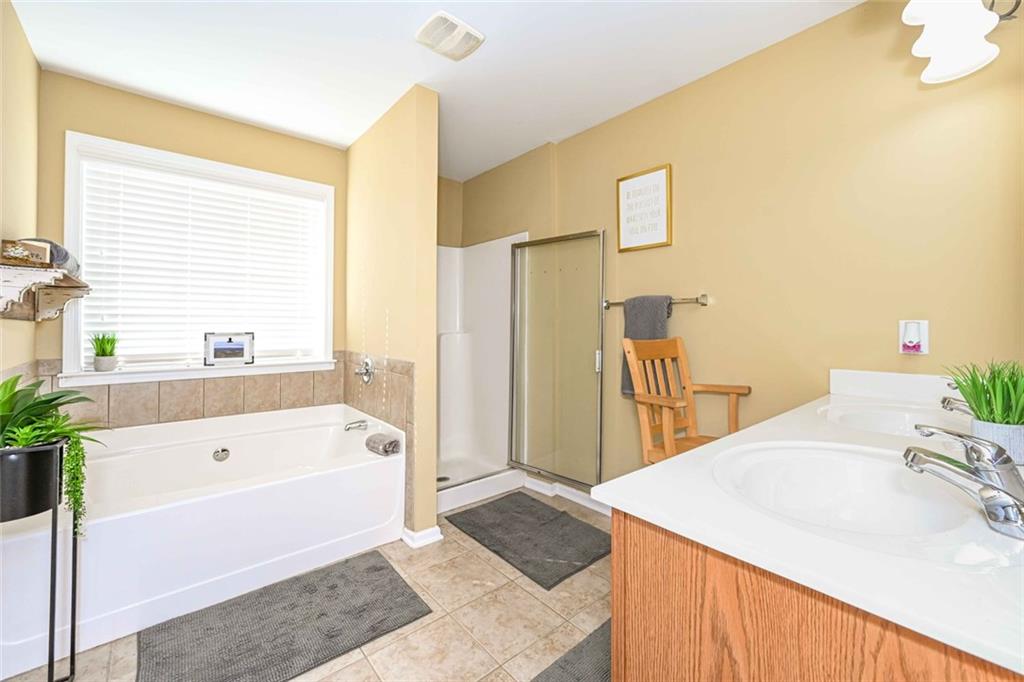 1024 Landon Drive Villa Rica, GA 30180 - Photo 31 of 50 a bathroom with a tub a sink and a large mirror